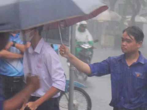 Tình nguyện viên dầm mưa hỗ trợ thí sinh